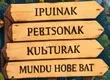 Carteles de madera: IPUINAK, PERTSONAK, KULTURAK, MUNDU HOBE BAT